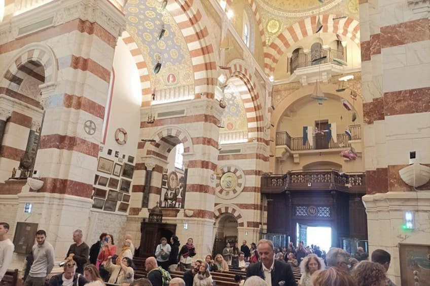 Un intérieur animé d’un bâtiment historique, avec des colonnes rayées et des plafonds richement décorés. 5