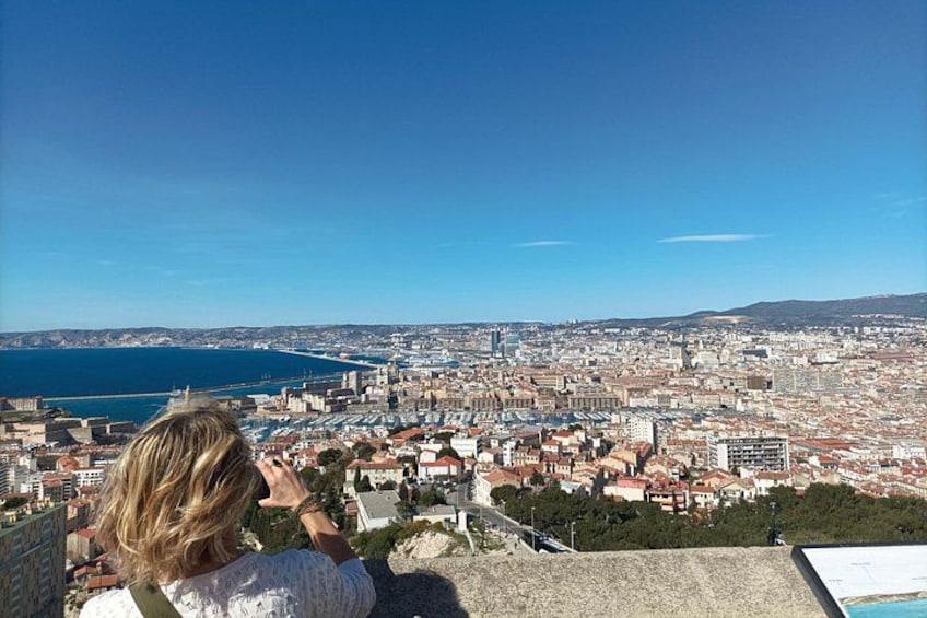 Une vue panoramique d’une ville côtière, avec un ciel bleu dégagé, une vaste étendue d’eau et une zone urbaine densément construite. 4