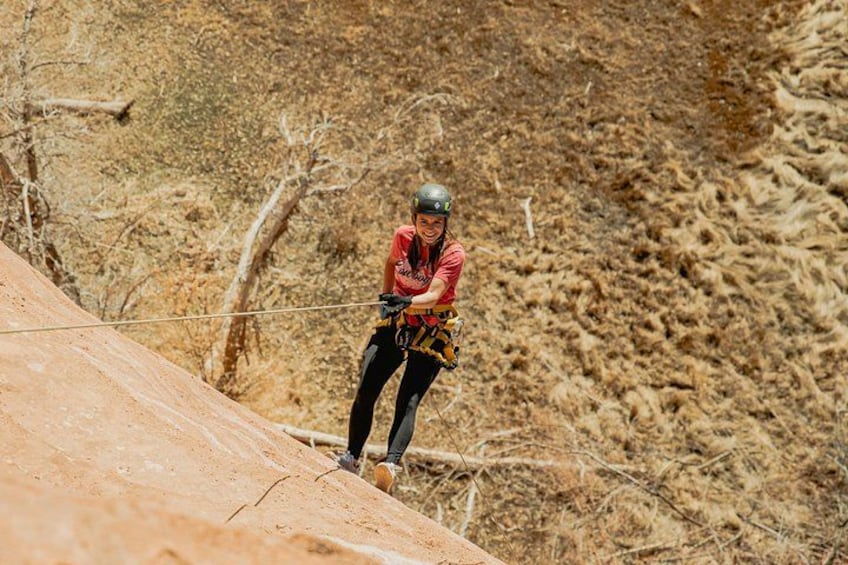 A person rappelling down a rocky slope. 2