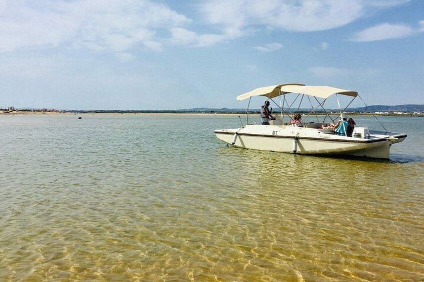 A small boat with a canopy on a calm body of water. 2