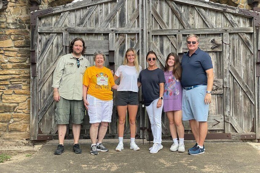 A group of people standing in front of a wooden barn structure. 2