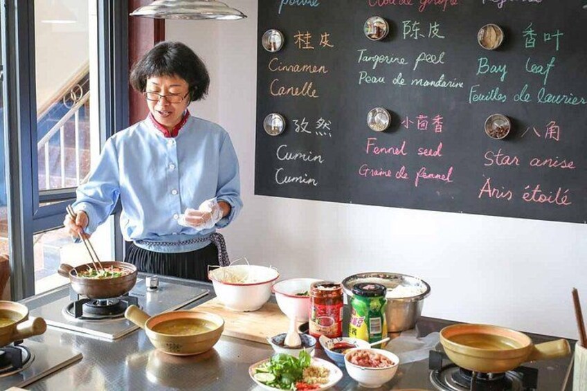 A person cooking in a kitchen with various ingredients and cookware on the counter. 1