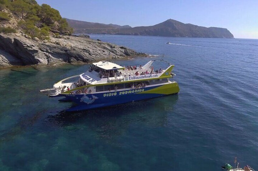 Ein Boot mit dem Namen VISIO SODOMARA auf klarem, blauem Wasser in der Nähe von felsigen Ufern. 1