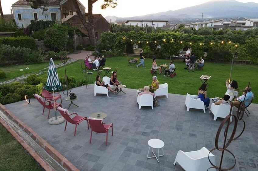 Ein Garten mit Außenbestuhlung, einem Brunnen und Blick auf die Stadt. 2