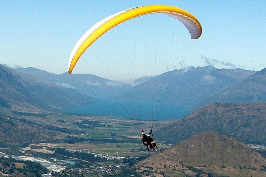 A person paragliding over a mountainous landscape with a valley below. 3