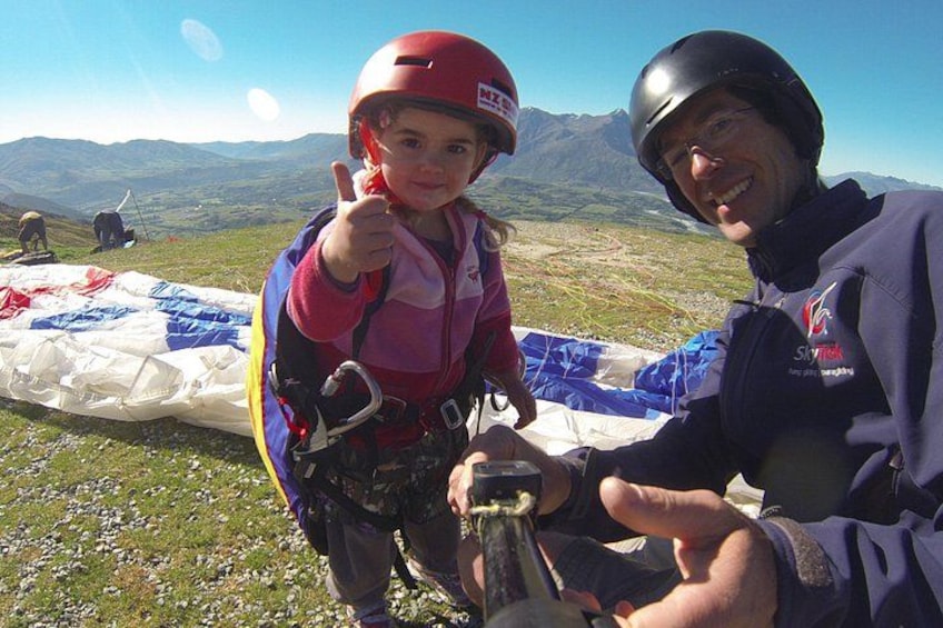 A person in a helmet and a child giving a thumbs-up gesture. 5