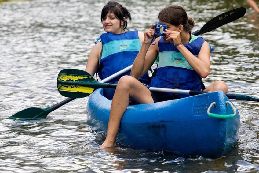 Two people in a blue inflatable raft on a body of water, each holding a paddle. 2