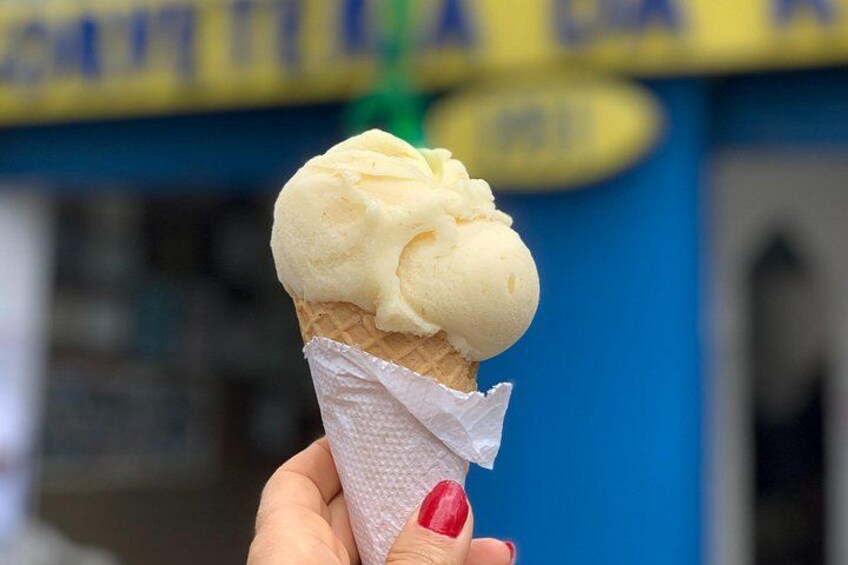 A hand holding a waffle cone with a scoop of ice cream. 2