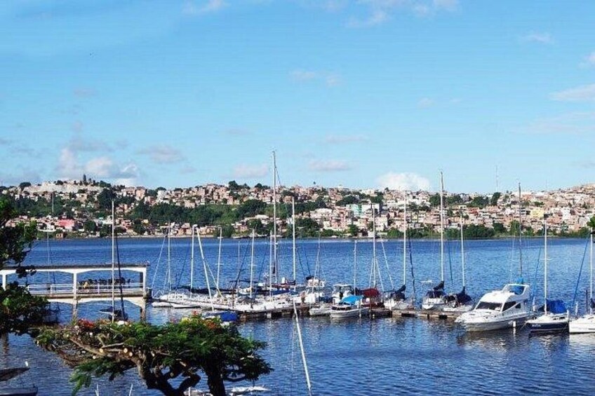 A harbor with boats, a dock, and a hillside settlement in the background. 4