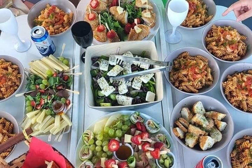 A table with various dishes including pasta, salads, and bread. 4