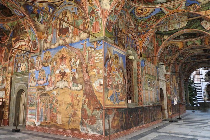 A richly decorated interior with intricate frescoes and arches. 4