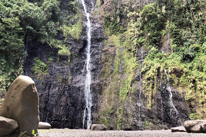 A waterfall cascading down a rocky cliff surrounded by lush greenery. 3