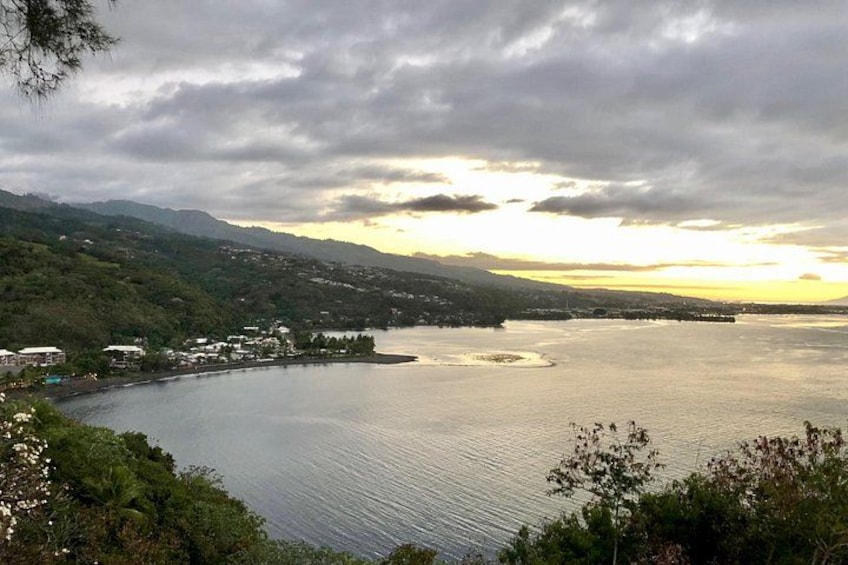 A lake surrounded by hills, a small town, and a sunset. 5