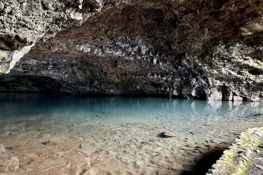 A cave with clear water and rocky walls. 2
