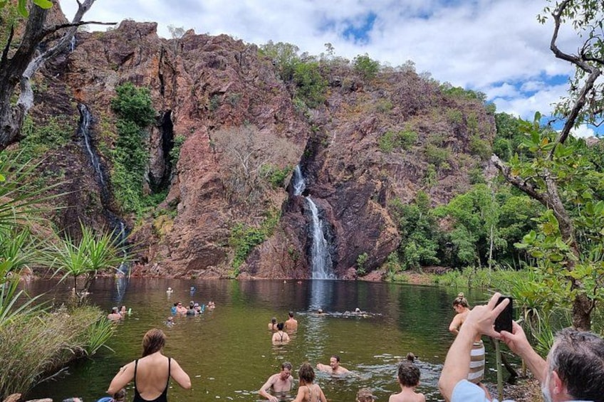 Een waterval, een meer, en mensen die zwemmen en ontspannen. 2