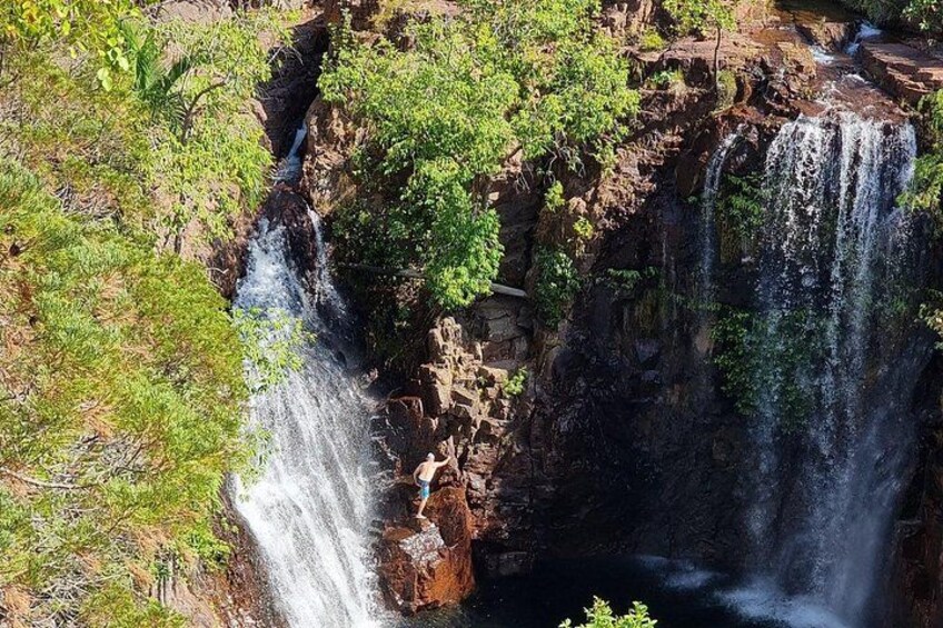 Een waterval die over een rotswand stroomt, omgeven door groen. 5