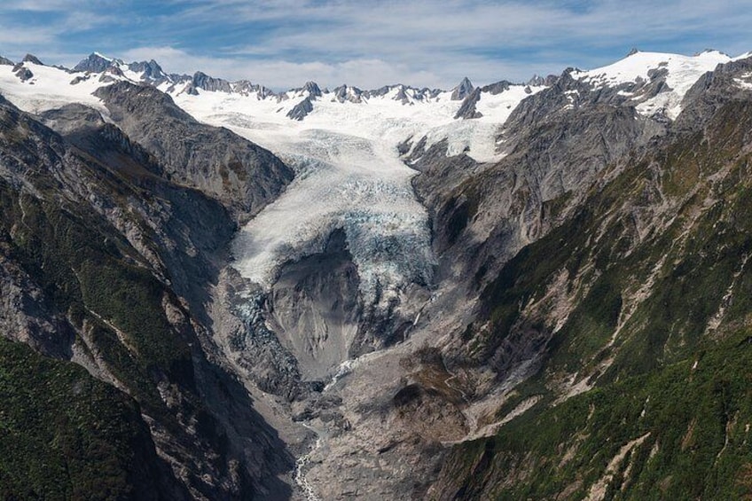 A glacier valley with steep mountain walls and snow-capped peaks. 2