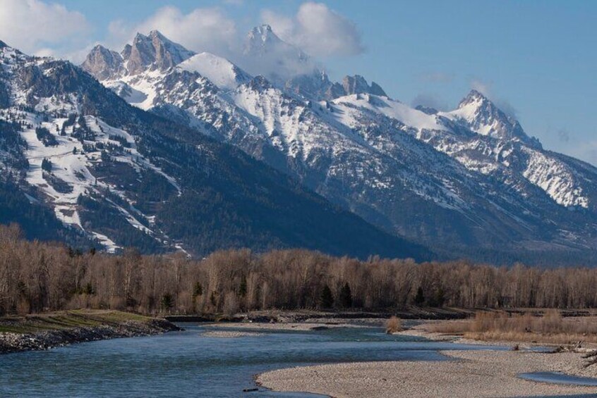 A river flowing through a valley with snow-capped mountains in the background. 2
