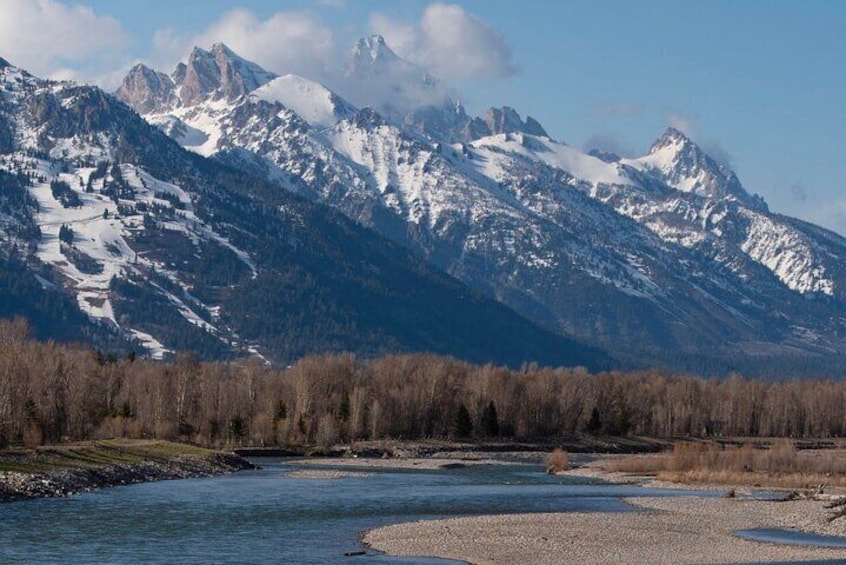 A river flowing through a valley with snow-capped mountains in the background. 3