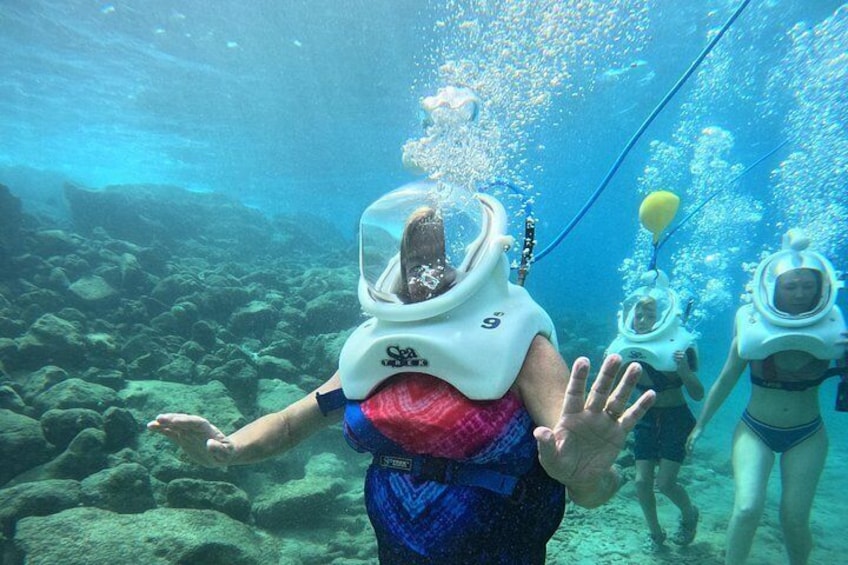 A person in a scuba diving mask with a snorkel, surrounded by underwater rocks and marine life. 5