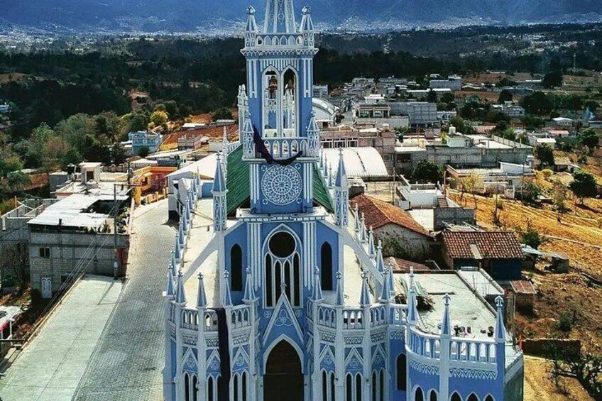 A large white church with a bell tower and a dome, surrounded by residential buildings. 3