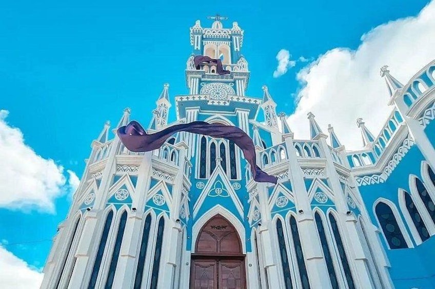 A large, ornate building with a blue and white facade, a prominent arched entrance, and a decorative roof. 4