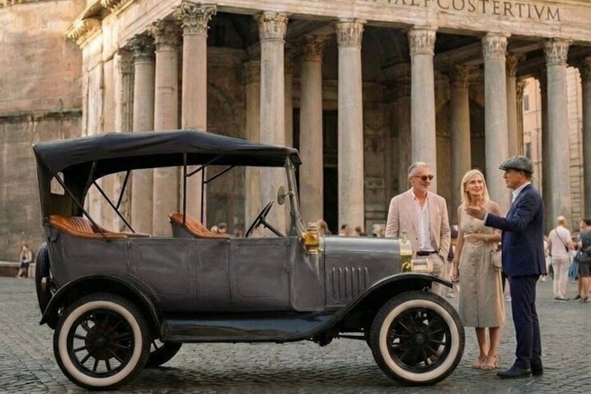 A vintage car parked in front of a classical building with columns. 4