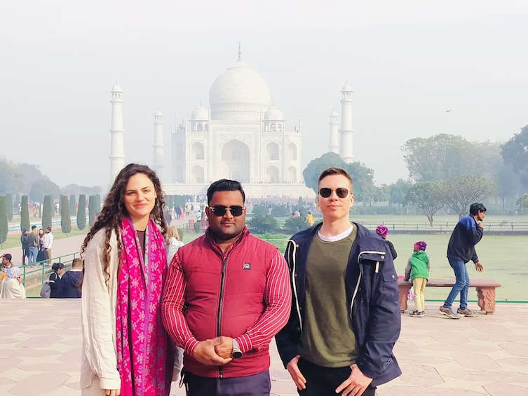 Tre persone in piedi di fronte al Taj Mahal. 1