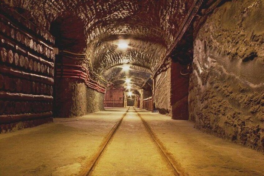 A tunnel with brick walls, a concrete floor, and a central railway track. 4