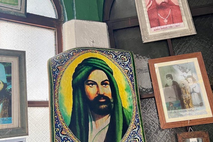 A framed portrait with a green and yellow background, surrounded by other framed pictures on a wall. 2