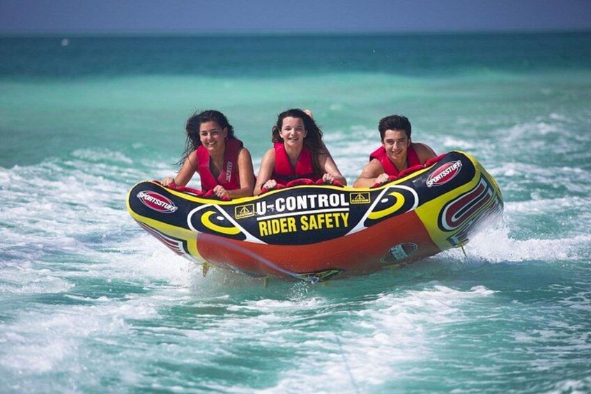 Three people in a U-Control Rider Safety jet ski on turquoise ocean water. 5