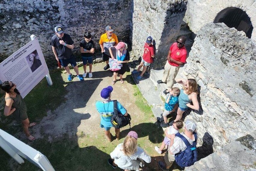A group of people gathered around a historical site with a signboard. 4
