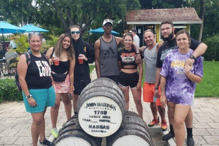A group of people standing in front of a barrel with a label. 5
