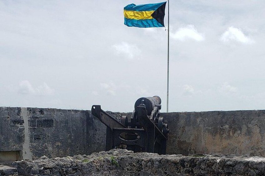 Un cañón sobre un muro de piedra con una bandera ondeando. 2