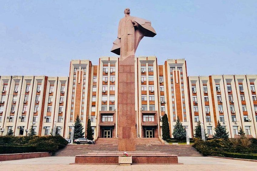 Une grande statue se dresse devant un immeuble à plusieurs étages. 5