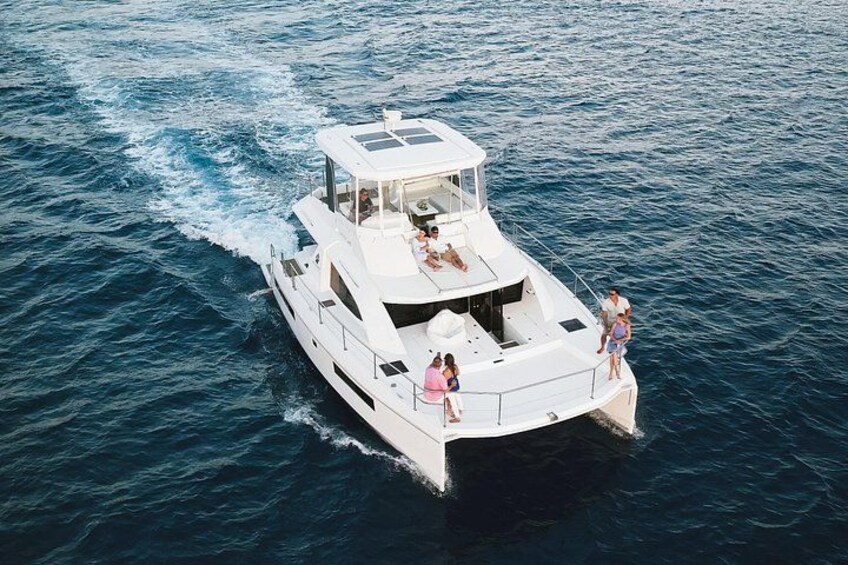 A white yacht on the water with people on deck. 3
