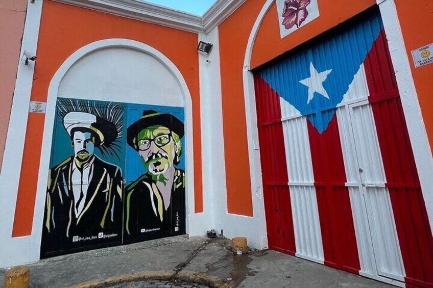 A building with a mural of two men and a red and white striped door. 3