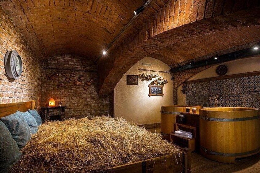 Una bodega rústica con barriles de madera, un fardo de heno y una pared de ladrillo. 4