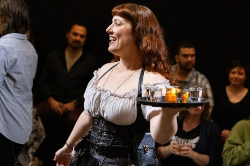 A person holding a tray with drinks and a bottle. 2