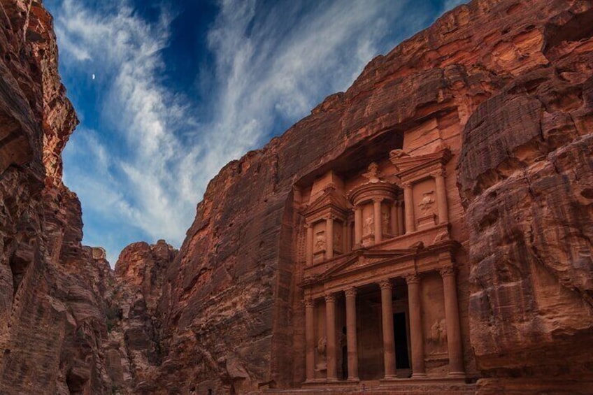A rock-cut architectural structure in a canyon with a clear sky. 5