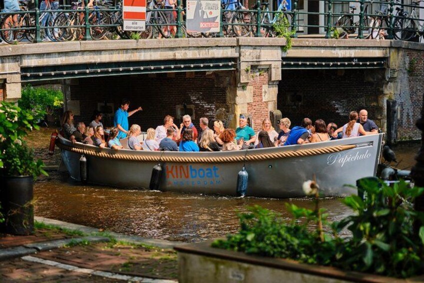 A boat with people on it, a bridge, and a canal. 3