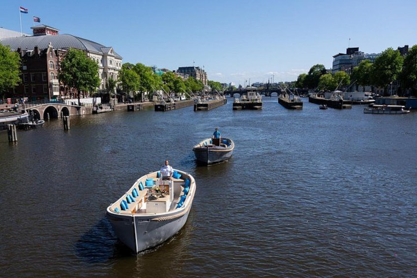 A canal with boats, a bridge, and buildings along the banks. 3