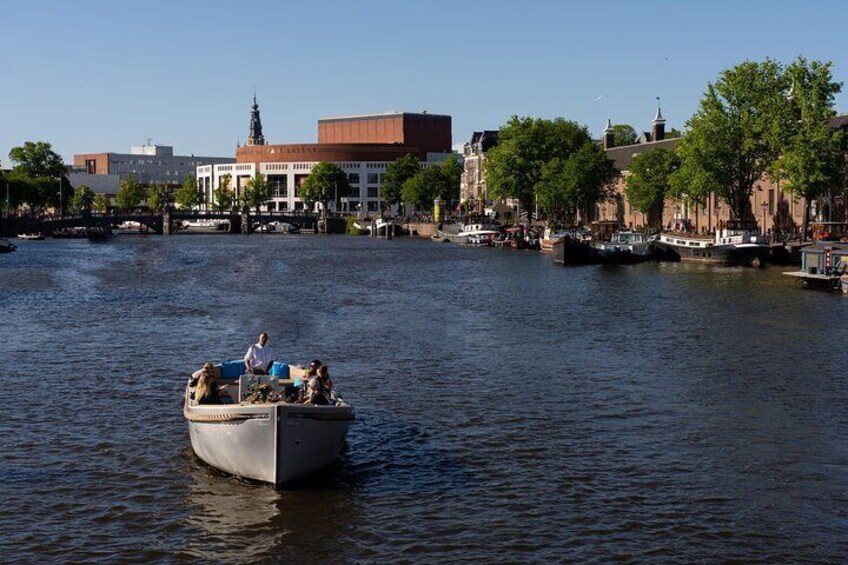 Un bateau sur une rivière, avec des bâtiments et des arbres en arrière-plan. 2