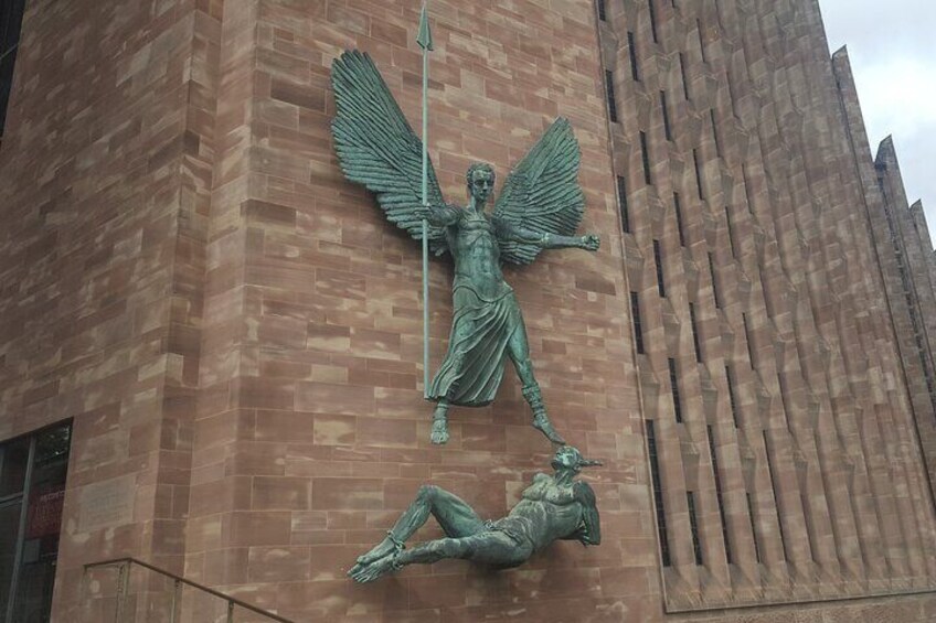 A bronze angelic statue on a building facade. 1