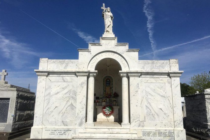 Ein Marmormonument mit einer Statue, einem Bogen und einem Kreuz. 5