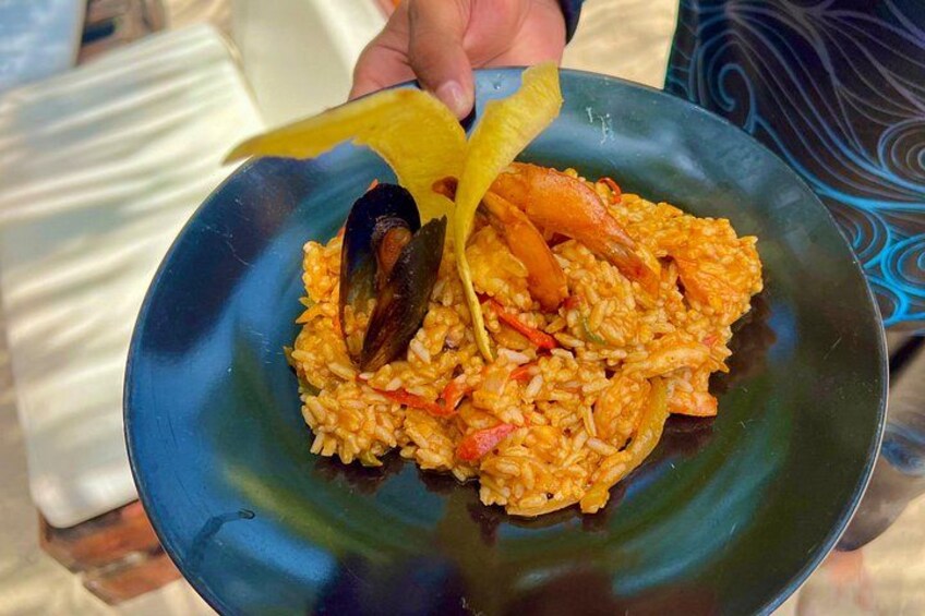 A plate of paella with seafood and vegetables. 2