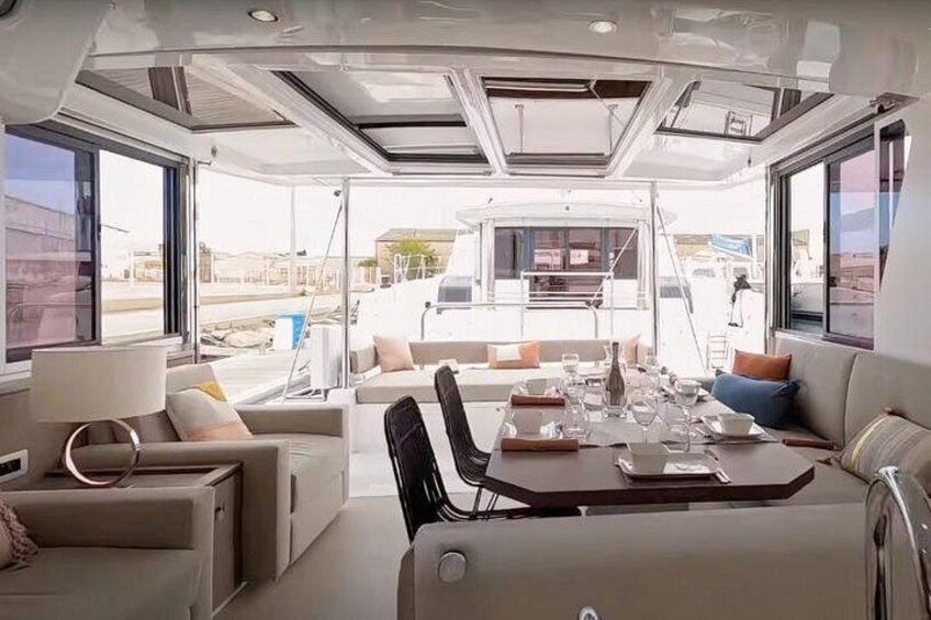A modern interior with a dining area, sofas, and large windows. 3