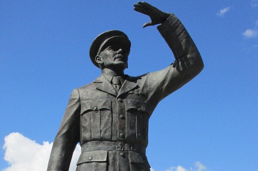 A statue of a person in a military uniform with a raised arm. 2