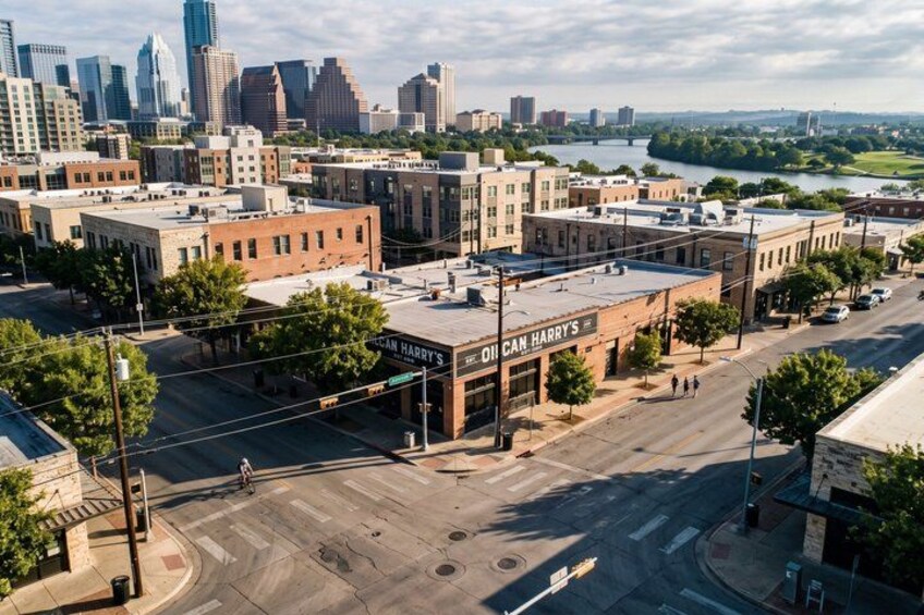 Une vue d’une ville avec un bâtiment imposant portant l’inscription « Oil Can Harry’s ». 2