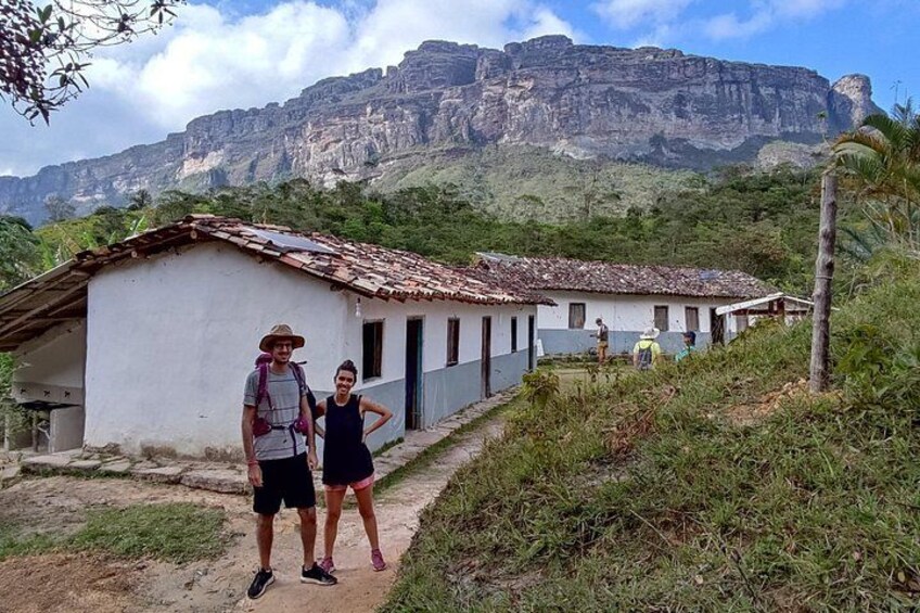 A rural scene with a white building, a person in a hat, and a child. 2
